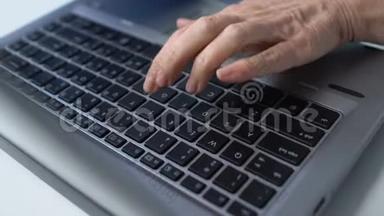 老年妇女在笔记本电脑上打字，为老年人学习现代课程